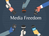 six arms holding microphones to represent media freedom